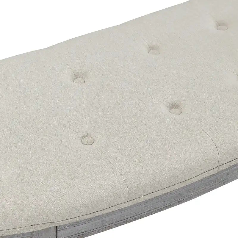 Banco tapizado beige con capitoné, de estilo costero y patas de madera